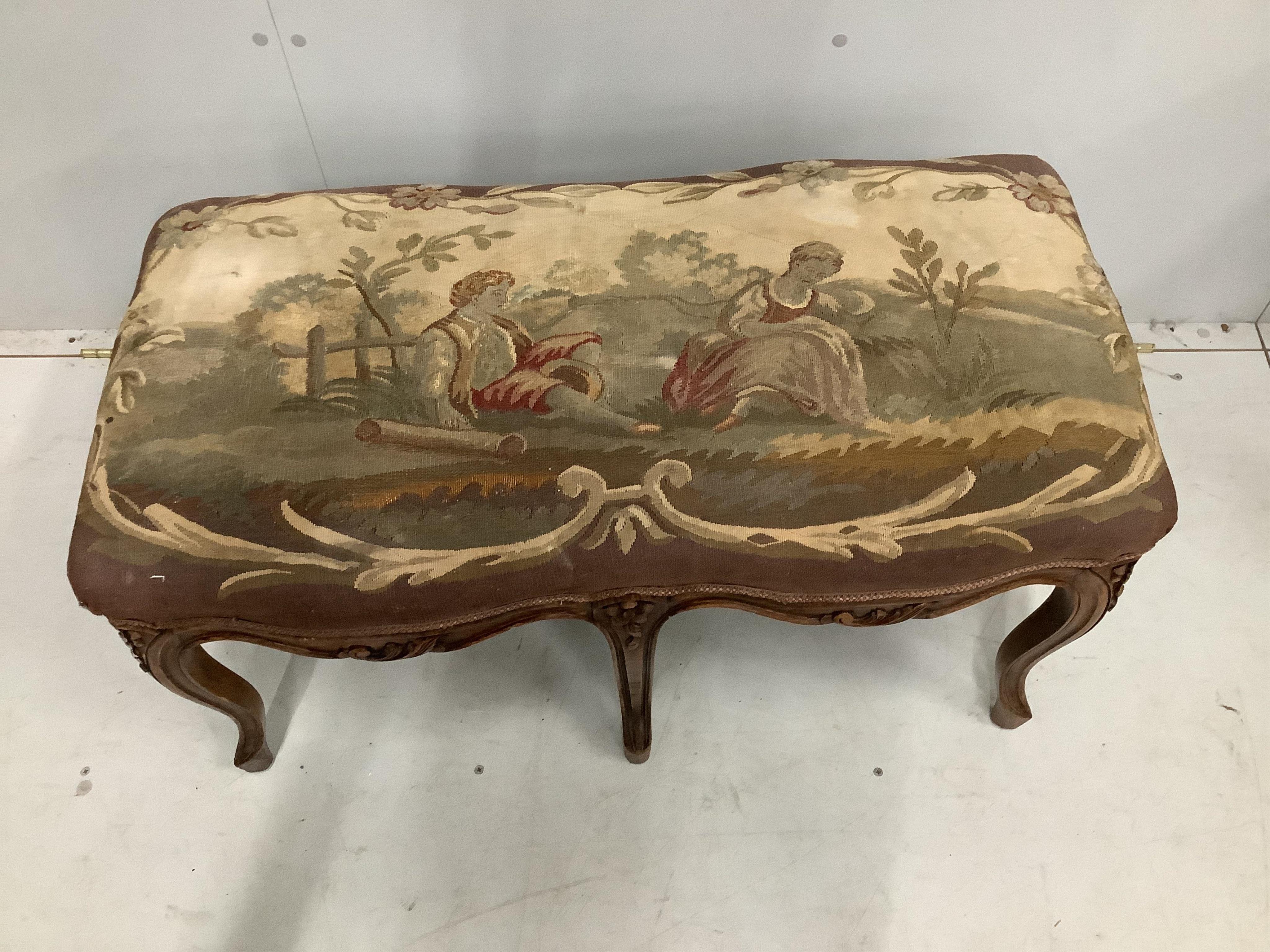 A French carved beech dressing stool, with an Aubusson style tapestry upholstered seat, width 88cm, height 46cm. Condition - fair